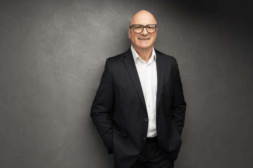 Dr. Christoph Müser lächelnd, Hände in den Taschen